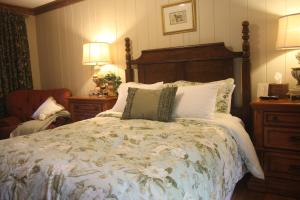 a bedroom with a large bed and a chair at Village Inn - Blowing Rock in Blowing Rock