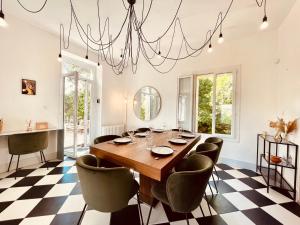 a dining room with a table and chairs and a chandelier at L'écrin Nimois in Nîmes
