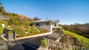 a house with a fence in front of it at Lune-tastic Guesthouse in Oamaru