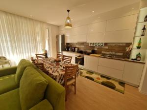 a living room with a table and a kitchen at Rozana's sweet home, San Pietro Resort, Gjiri i Lalzit in Lalzit Bay