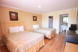 una camera d'albergo con due letti e una televisione di Sinbad Motel a Miami