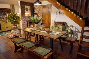 a dining room with a wooden table and stairs at Horská chata 3 SKALKY so saunou a jacuzzi kaďou in Smižany