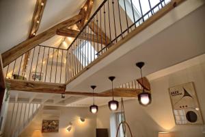 a staircase in a room with wooden beams and lights at Gîte le Grenier GRAY in Gray