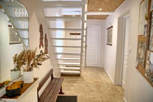 a hallway with stairs with a bench and a door at Gîte le Grenier GRAY in Gray