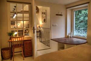 a bedroom with a desk and a bed and a window at Gîte le Grenier GRAY in Gray