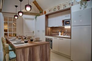 a kitchen with a table and a white refrigerator at Gîte le Grenier GRAY in Gray