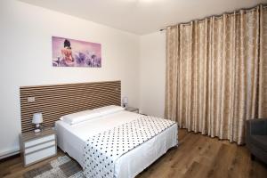 a bedroom with a white bed and curtains at Martina 2 in Marghera