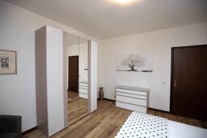 a bedroom with white walls and a large mirror at Martina 2 in Marghera