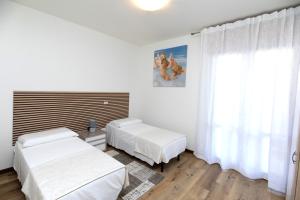 a bedroom with two beds and a window at Martina 2 in Marghera