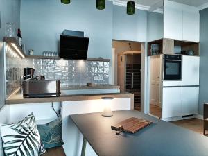 a kitchen with white cabinets and a table with a lamp at Fürstenhof Sassnitz - PANORAMA103 in Sassnitz