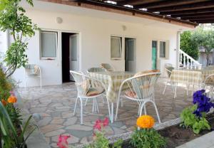 Un patio con mesa y sillas y flores. en Apartments Vinko, en Vir