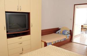 Habitación con TV y dormitorio con cama. en Apartments Vinko, en Vir