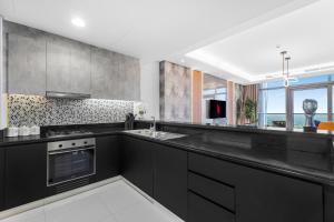 a kitchen with a black counter top and a sink at 64th floor Skyline Pool with Burj Khalifa View in Paramount Hotel Midtown in Dubai