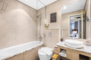 a bathroom with a sink and a toilet and a tub at 64th floor Skyline Pool with Burj Khalifa View in Paramount Hotel Midtown in Dubai