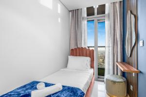 a small bedroom with a bed and a window at 64th floor Skyline Pool with Burj Khalifa View in Paramount Hotel Midtown in Dubai