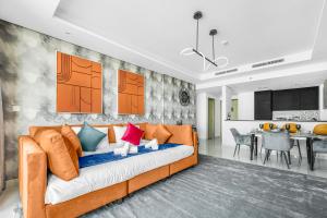 a living room with an orange couch with colorful pillows at 64th floor Skyline Pool with Burj Khalifa View in Paramount Hotel Midtown in Dubai