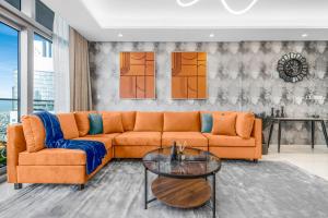 a living room with an orange couch and a glass table at 64th floor Skyline Pool with Burj Khalifa View in Paramount Hotel Midtown in Dubai