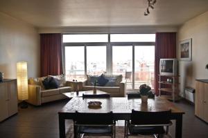 a living room with a table and a large window at City Apartments Antwerpen in Antwerp