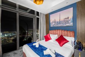 a bedroom with a bed with red pillows and a large window at 64th floor Skyline Pool with Burj Khalifa View in Paramount Hotel Midtown in Dubai
