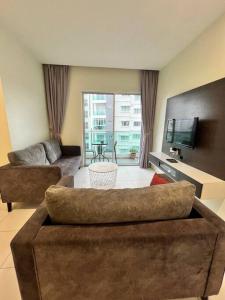 a living room with a couch and a tv at Lily Brava 5 in Tanah Rata