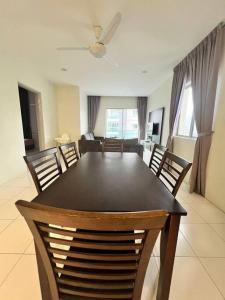 a dining room table and chairs in a living room at Lily Brava 5 in Tanah Rata
