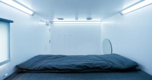 uma cama num quarto com uma luz azul em Bobopod Airport CBC, Tangerang em Rawalembang