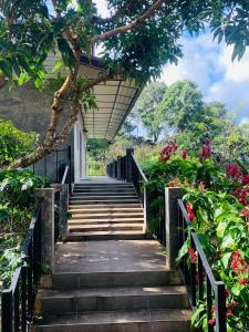 eine Treppe, die zu einem Haus mit Blumen führt in der Unterkunft DC Farm House in Ban Huai Khai