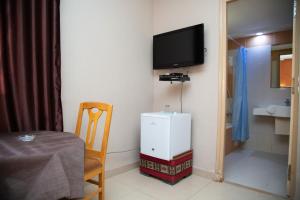 a room with a small refrigerator and a tv on the wall at Résidence El Arich in Tozeur +37 photos