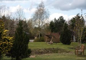 un parco con altalena incastonata nell'erba di Harvest 8 Lodge, Yellowtop Country Park a York