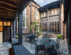 a patio with tables and chairs in a building at Luttrell Arms in Dunster