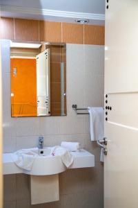 a bathroom with a sink and a mirror at Résidence El Arich in Tozeur