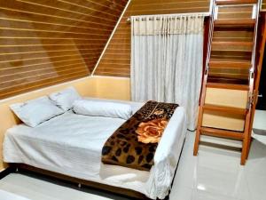a bedroom with a bed with a leopard blanket at UNIQDO Inn Tomok in Tomok