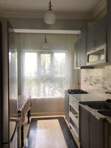 una cucina con finestra, lavandino e piano cottura di LUKA a Kobuleti