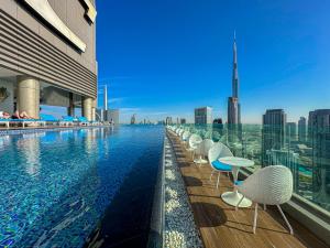 a swimming pool on top of a building at 64th floor Skyline Pool with Burj Khalifa View in Paramount Hotel Midtown in Dubai