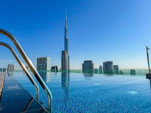 a swimming pool with a view of the burj skyscraper at 64th floor Skyline Pool with Burj Khalifa View in Paramount Hotel Midtown in Dubai