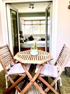 a wooden table and two chairs on a porch at Avenue_1Barnes in Westgate on Sea