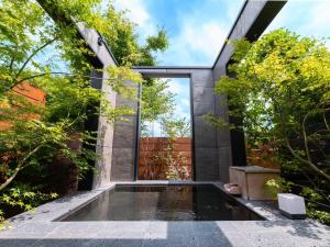 由布市Yufuin Glamping COMOREBI的花园中树木繁茂的游泳池