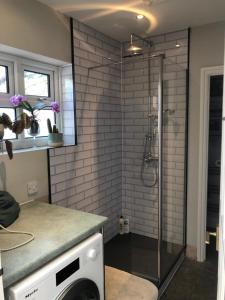 a shower with a glass door in a bathroom at Avenue_1Barnes in Westgate on Sea +79 photos