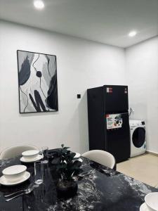 a dining room with a table with chairs and a refrigerator at 3 Story House With Jacuzzi PlyGround 18Pax Melaka Town 10min Jonker in Tranquerah