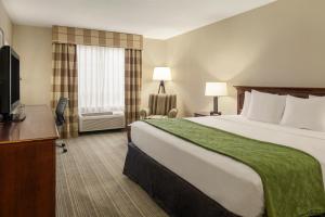Pokój hotelowy z dużym łóżkiem i telewizorem w obiekcie Country Inn & Suites by Radisson, Lima, OH w mieście Lima