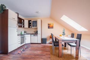 a kitchen and dining room with a table and chairs at Apartment im Seepark in Naunhof
