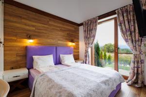 a bedroom with a purple bed and a large window at Mountain villa Aleksia- with JACUZZI in Razlog +36 photos