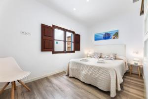 a white bedroom with a bed and a window at Albercutx Pollentia 1 2 3 in Port de Pollensa