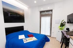 a bedroom with a blue bed in a white room at A casa di Anna IO CI VADO in Lucera