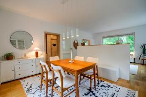a dining room with a wooden table and chairs at Beheizter Whirlpool und Panoramafenster vom Bett ins Grüne! in Kassel