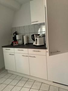 a kitchen with white cabinets and white appliances at Ferienwohnung im Schloss Obersontheim in Obersontheim +9 photos
