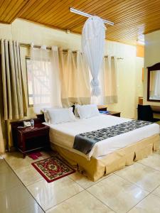 キガリにあるKigali diplomat Hotelの部屋の中に大きなベッドがある寝室