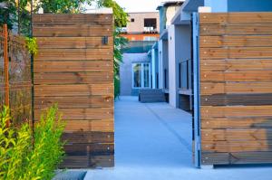 a wooden fence next to a sidewalk next to a building at VIP next TIME Casa Vacanta in Costinesti