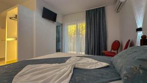 a bedroom with a bed with a dress on it at VIP next TIME Casa Vacanta in Costinesti +8 photos