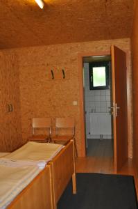 a room with two beds and an open door at Gästedorf Waldheimat in Langenwang